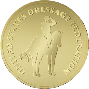 A gold coin features a rider on a horse in the center, with the text UNITED STATES DRESSAGE FEDERATION engraved around the edge.