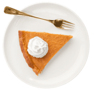 A slice of pumpkin pie topped with whipped cream on a white plate, with a gold fork placed beside it—perfect for savoring after a day of Black Friday 2022 shopping or while giving back during the holiday season.