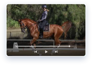 A person wearing a helmet and patterned shirt is riding a chestnut horse in an outdoor arena, demonstrating Flyer changes. Trees and a fence are visible in the background as the scene appears on a video player at the 7:18 mark of an 8:39 video.