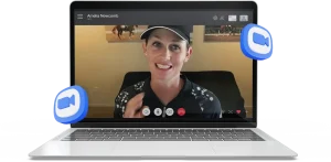 A laptop screen displaying a video call with a smiling woman in a black cap and patterned shirt; Zoom logos float around the laptop, capturing the energy of a virtual Training Masterclass.