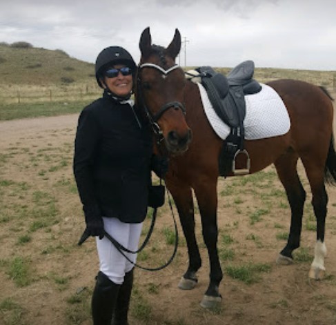 Online student Debi posing with her dressage horse.