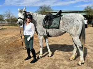 Carole Weamer posing and smiling with her horse.