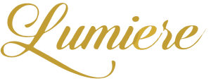 The word Lumiere is written in elegant, gold cursive script on a plain, white background, evoking the refined artistry and grace found in expert dressage training.