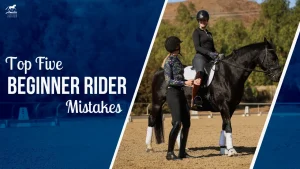 A riding instructor stands beside a smiling rider on a black horse in an outdoor arena, offering riding tips for balanced riding. Text on the image reads, Top Five Beginner Rider Mistakes. Trees and hills are visible in the background.